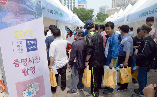 서울시가 25일 서울광장에서 개최한 ‘취업 취약계층 일자리 박람회’에 참석한 구직자들이 이력서에 넣기 위한 사진을 찍기 위해 줄을 서 있다. 이번 박람회는 서울시가 추진하는 ‘2016년 노숙인 일자리 종합대책’의 하나로 50여개 민간 기업이 참여했다.  /이호재기자