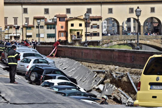 25일(현지시간) 이탈리아 피렌체 아르노 강변의 지반이 꺼지면서 길가에 주차된 차량 약 20대가 구덩이에 빠진 모습./피렌체=AP연합뉴스