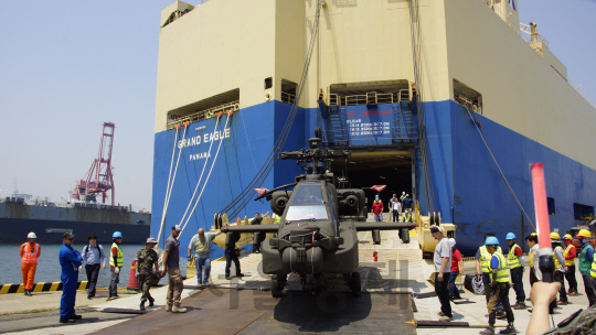 한국군이 운용할 아파치 공격헬기 36대 가운데 1차분 4대가 26일 부산항을 통해 들어왔다. 파나마 선적 화물선 그랜드이글호에서 보잉사와 한국 육군 관계자들이 아파치 헬기를 하역하고 있다. /사진제공=방위사업청
