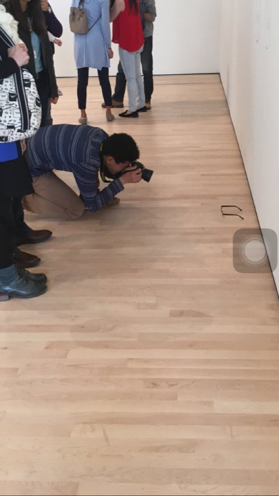 관람객들이 바닥에 떨어진 안경을 촬영하고 있다./출처=트위터