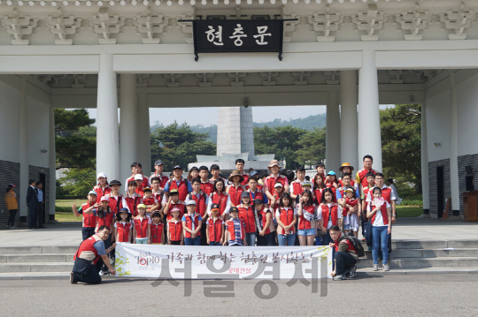 지난 28일 국립 서울 현충원에서 진행된 봉사활동에 참여한 롯데건설 임직원 가족들이 현충문 입구에서 단체사진을 찍고 있다./사진제공=롯데건설.