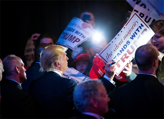 2월 15일 사우스 캐롤라이나에서 열린 도널드 트럼프의 선거 유세에서 지지자들이 사인을 받기 위해 손을 뻗고 있다.