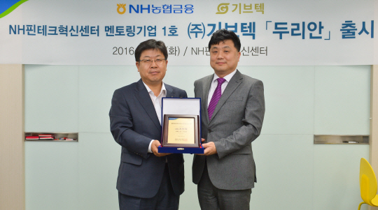 이경섭(왼쪽) NH농협은행장이 31일 서울 서대문구 NH핀테크혁신센터에서 김승기 기브텍 대표에게 NH핀테크혁신센터 멘토링기업 1호 명패를 전달하고 기념촬영을 하고 있다./사진제공=NH농협은행