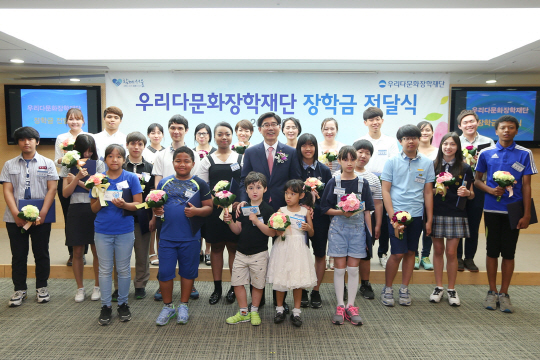 이광구(가운데) 우리은행장 겸 우리다문화장학재단 이사장이 2일 서울 중구 우리은행 본점에서 다문화 학생들에게 장학금을 전달한 후 참석자들과 함께 기념 촬영을 하고 있다. 우리다문화장학재단은 초중고 및 대학교 재학생 390명에게 2억4,100만원을 장학금을 전달했다./사진제공=우리은행