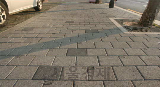 데코페이브의 투수코어 보도블록이 서울 성수구 성수문화예술회관 앞 길에 시공돼 있다. 보도블록 왼쪽 상단의 모서리에 위치한 투수코어를 고압세척기로 청소하면 보도블록의 투수 효과를 기존 보도블록보다 더 지속할 수 있다. /사진제공=데코페이브