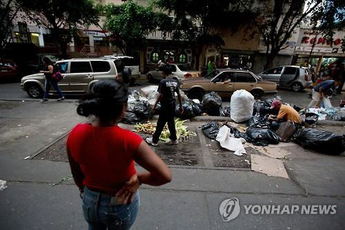 쓰레기 더미에서 먹을 만한 채소를 골라내고 있는 어린 소녀들. /연합뉴스