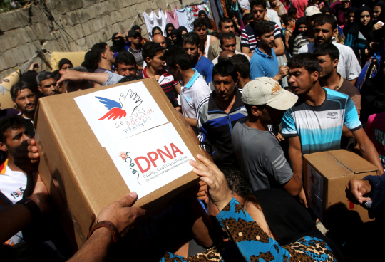 프랑스의 한 비영리단체가 시리아 난민에게 구조물품을 전달하고 있다. /연합뉴스