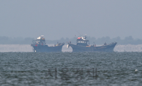 한강하구 중립구역(DMZ)에서 불법조업중이던 중국 어선들이 우리측의 경고방송과 단속 작전이 시작되자 도주에 앞서 어구를 거두고 있다./합동참모본부 제공