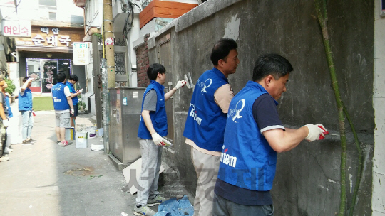 현대로템 직원들이 10일 서울역 쪽방촌을 찾아 낙후된 골목길 외벽에 페인트 칠하기 봉사활동을 펼치고 있다./사진제공=현대로템
