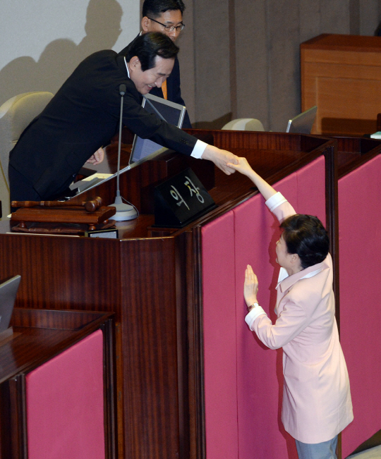 박근혜 대통령이 13일 국회 본회장에서 제20대 국회 개원 축하 연설을 마친 뒤 까치발로 서서 손을 내밀어 정세균 국회의장과 악수하고 있다. /이호재기자