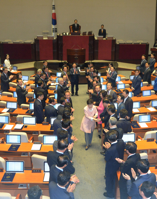 박근혜 대통령이 13일 20대 국회 개원 연설을 마친 뒤 기립한 의원들과 악수하며 본회의장을 빠져나가고 있다. /이호재기자