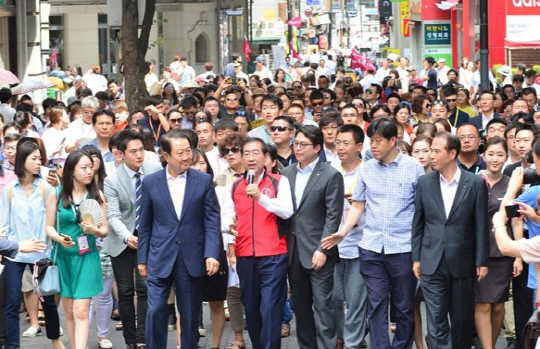 지난해 7월 아시아나항공이 개최한 명동 걷기 행사 현장 모습. 현장을 찾은 박원순 서울시장(가운데)이 일일 가이드로 변신해 명동 일대를 소개하고 있다.