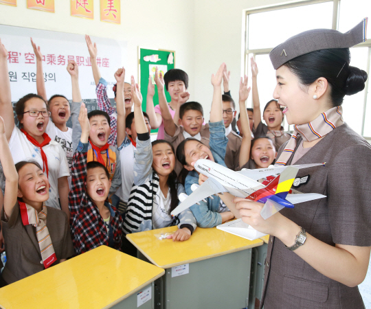 아시아나항공 승무원이 14일 중국 장쑤성 예청시 서양현 신탄소학교에서 직업에 대한 강연을 하고 있다. 아시아나항공은 이날 강연과 더불어 컴퓨터 8대와 책걸상 400개, 도서 1,000권 등 학습용 교육기자재를 지원하는 ‘아름다운 교실’자매결연 행사를 가졌다./사진제공=아시아나항공