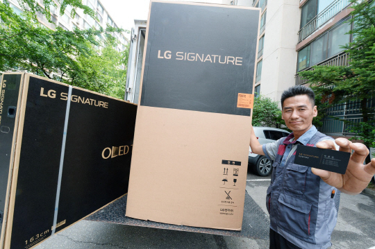‘LG 시그니처’ 전문설치명장이 16일 서울 영등포구 여의도동의 한 아파트에 설치할 LG 시그니처 냉장고와 LG 시그니처 올레드 TV를 배송차량에서 내리고 있다. /사진제공=LG전자