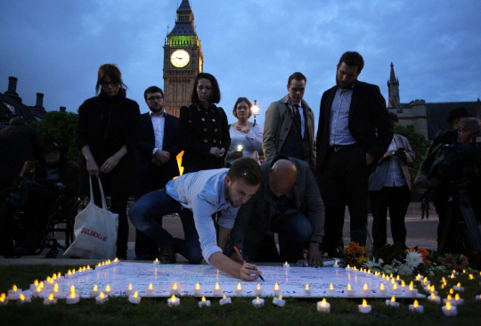 16일(현지시간) 영국 런던의 팔리아먼트 광장에서 시민들이 노동당 조 콕스 하원의원의 죽음을 애도하며 촛불을 밝히고 화이트보드에 추모의 글을 남기고 있다./런던=AFP연합뉴스