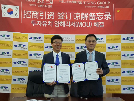 김언식(오른쪽) 디에스삼호 회장과 장명주 베이징브릿징컨설팅 회장이 17일 중국 베이징에서 용인 바이오메디컬BIX 개발사업 추진을 위한 양해각서를 체결하고 있다. / 사진제공=디에스디삼호