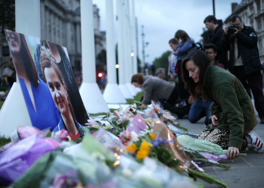 Floral tributes and candles are placed by a picture of slain Labour MP Jo Cox at a vigil in Parliament square in London on June 16, 2016.  Cox died today after a shock daylight street attack, throwing campaigning for the referendum on Britain‘s membership of the European Union into disarray just a week before the crucial vote.   / AFP PHOTO / DANIEL LEAL-OLIVAS      <저작권자(c) 연합뉴스, 무단 전재-재배포 금지>