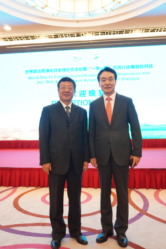김용하(사진 오른쪽) 산림청 차장이 장 지엔롱(〃왼쪽) 중국 임업국  장관을 만나 세계산림총회 한국유치 지지를 당부하고 포즈를 취하고 있다. 사진제공=산림청