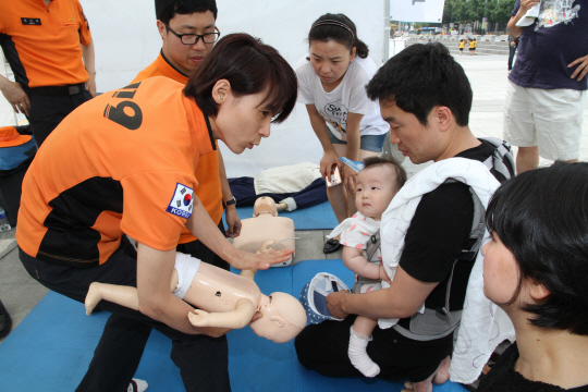 서울 관악소방서 119구조대원이 19일 종로구 광화문광장 희망나눔장터 안전체험교실 부스에서 신생아 기도폐쇄 응급처치법과 심폐소생술 시범을 보이고 있다. /사진제공=관악소방서