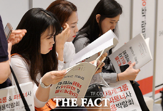 21일 서울 삼성동 코엑스에서 열린 ‘신세계그룹 & 파트너사 상생채용박람회’에서 구직자들이 채용 책자를 살펴보고 있다.