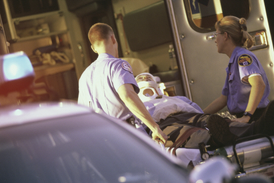 Paramedics putting a patient into an ambulance