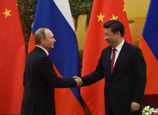 블라디미르 푸틴(왼쪽) 러시아 대통령과 시진핑 중국 국가주석이 25일 중국 베이징 인민대회당에서 중러 정상회담 기자회견을 마치고 악수하고 있다. 외교 전문가들은 브렉시트로 영국이라는 핵심 동맹의 힘이 약화하면서 미국의 패권 전략이 흔들리고 중국과 러시아의 영향력이 커질 수 있다고 예상했다.  /베이징=EPA연합뉴스