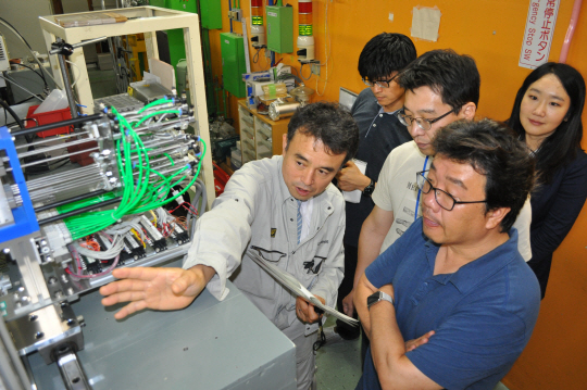 아츠시 요시다(왼쪽) 일본 리켄 니시나 가속기센터 산학협력팀장이 마모진단 실험을 진행 중인 중이온가속기 장치와 실험 내용을 한국 연구진에게 설명하고 있다. /와코=박희윤기자