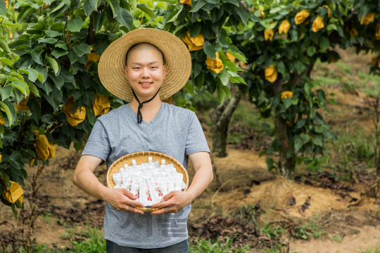 청년 농부 김바우씨와 그가 만든 과일주스./사진제공=신세계백화점