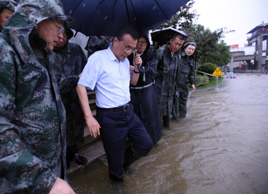 리커창(왼쪽 두 번째) 중국 총리가 6일 허베이성 우한을 방문해 최근 폭우로 불어난 강물에 발을 담그며 홍수 실태를 살펴보고 있다. 허베이성·안후이성 등 중국 남부에서는 지난달 30일 이후 계속된 집중호우로 사망·실종자가 200명에 육박하는 등 피해가 확산되고 있다. /우한=AFP연합뉴스