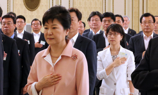 박근혜 대통령이 8일 청와대에서 열린 새누리당 지도부 및 의원과의 오찬간담회에서 국기에 대한 경례를 하고 있다. 뒷편에 유승민 의원의 얼굴이 보인다. /연합뉴스