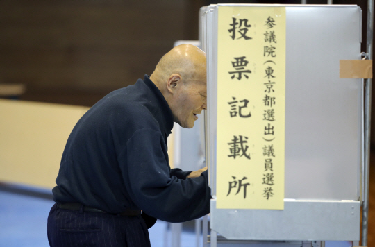 10일 도쿄의 한 투표소에서 유권자가 투표용지에 지지하는 후보를 표시하고 있다. /도쿄=AP연합뉴스