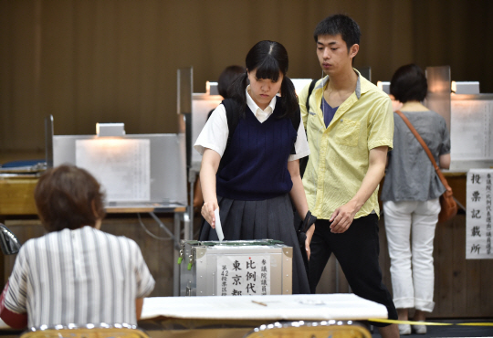 지난 10일 일본 도쿄의 한 투표소에서 교복을 입은 학생이 투표함에 용지를 넣고 있다. /도쿄=AFP연합뉴스