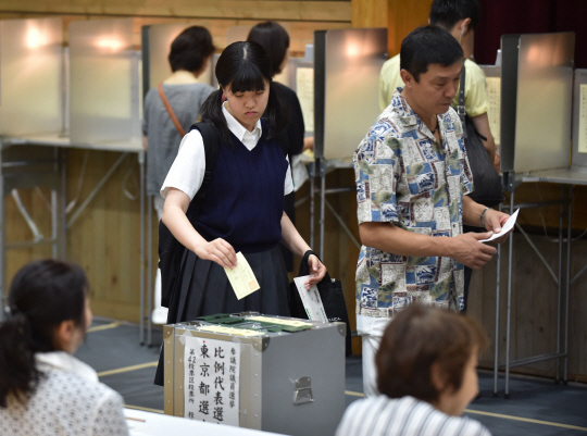 지난 10일 도쿄의 한 투표소에서 교복을 입은 학생이 투표함에 투표용지를 넣고 있다./도쿄=AFP연합뉴스