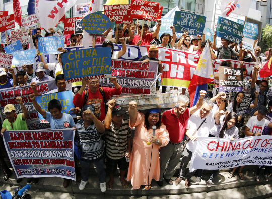 epa05421271 Filipino protestors hold placards as they protest against China‘s territorial claims over the disputed Spratlys group of islands outside the Chinese consular office in Makati city, south of Manila, Philippines, 12 July 2016. According to the leader of the demonstrators, the mass action made ahead of the expected ruling of the International Tribunal of the Permanent Court of Arbitration on a case the Philippines brought in 2013 against China’s claims in the South China Sea.  EPA/FRA