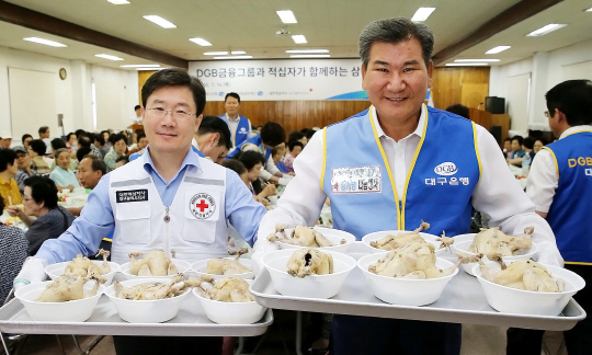 박인규 DGB금융그룹 회장이 14일 대구 경북지역 노인복지시설에서 열린 ‘사랑의 복삼계탕’ 나눔행사에서 삼계탕을 나르고 있다. 이날 DGB동행봉사단 500여명은 지역 노인 복지시설 40개소 어르신 6000여명에게 삼계탕, 수박, 간식 등을 제공했다./사진제공=DGB금융