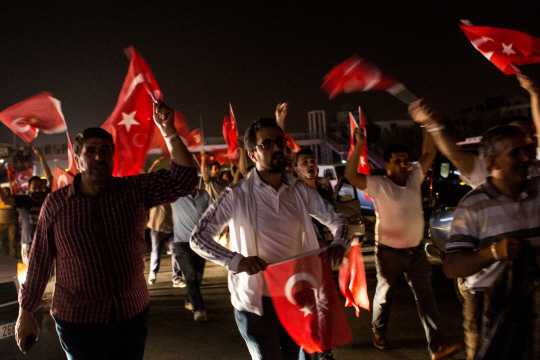 16일(현지시간) 터키 안탈리아에서 현 레제프 타이이프 에르도안 대통령을 지지하는 사람들이 거리로 나와 터키 국기를 흔들고 있다. 전날 밤 터키 군부는 군사력을 동원해 이스탄불 도심을 차지한 것으로 알려졌다. /안탈리아=AFP연합뉴스