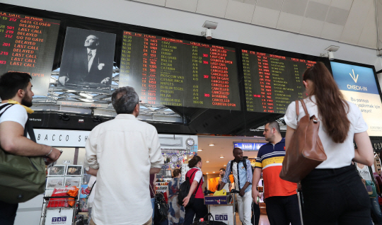 16일(현지시간) 터키 이스탄불 아타튀르크 국제공항에서 사람들이 항공편 출도착 여부를 알려주는 전광판을 바라보고 있다. 전날 밤 군부가 쿠데타를 시도하면서 폐쇄됐던 아타튀르크 공항은 16일 오후 다시 정상운행을 시작했다. /이스탄불=EPA연합뉴스