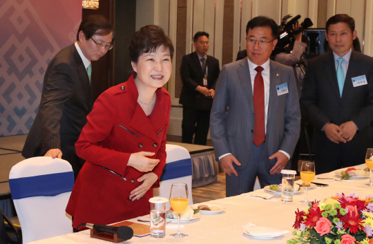 박근혜 대통령이 17일 몽골 울란바토르의 한 호텔에서 열린 동포간담회에 참석해 인사를 마치고 자리에 앉고 있다. /울란바토르=연합뉴스