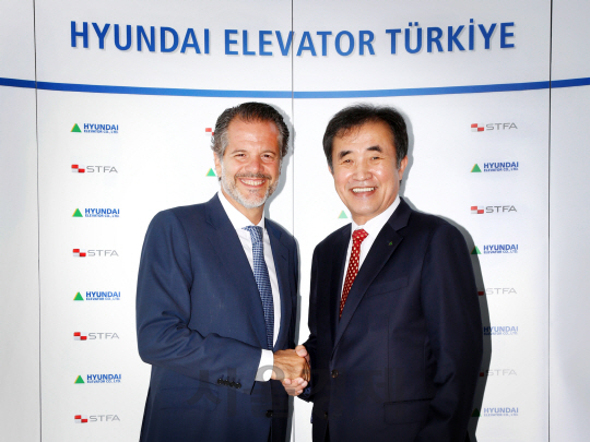 장병우 현대엘리베이터 대표이사(오른쪽)와 알프 얄친 타쉬켄트 STFA 이사가 19일(현지시간) 터키 이스탄불 STFA그룹 본사에서 열린 조인트벤처 계약 체결식 후 악수를 하고 있다./사진제공=현대엘리베이터