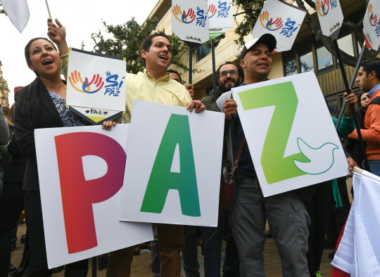 콜롬비아 헌법재판소가 정부와 최대 반군 콜롬비아무장혁명군(FARC) 간 막바지 협상 중인 평화협정안을 국민투표로 최종 승인하겠다고 19일(현지시간) 발표하자 시민들이 수도 보고타에서 헌재 결정에 환호를 보내고 있다. 정부는 평화협정 체결 후 1개월 이내에 국민투표를 요청할 수 있으며 전체 유권자의 13%에 해당하는 400만명의 찬성표를 얻으면 52년간 이어져온 내전이 끝나게 된다.     /보고타=AFP연합뉴스