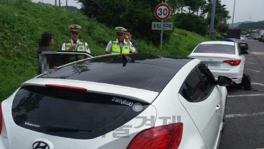 암행순찰 경찰관들이 23일 갓길 운전을 한 운전자에게 교통법규 위반사실을 설명하고 있다./박우인기자
