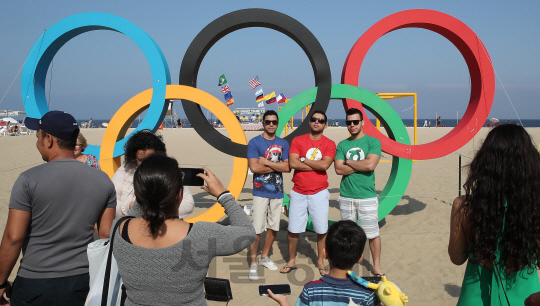 25일 오후(현지시간) 브라질 리우데자네이루 코파카바나 해변에 설치된 오륜기 조형물 앞에서 관광객들이 기념사진을 찍고 있다. /리우=이호재기자