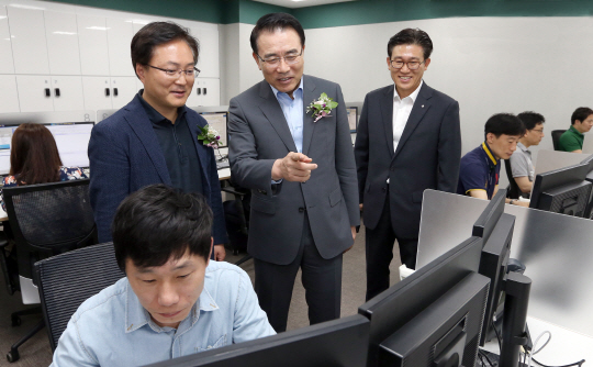 조용병(가운데) 신한은행장이 26일 서울시 강남구 역삼동에 위치한 신한은행 스마트워킹센터에서 유주선 신한은행 노동조합 위원장과 함께 직원들이 일하는 사무공간을 둘러보고 있다. /사진제공=신한은행