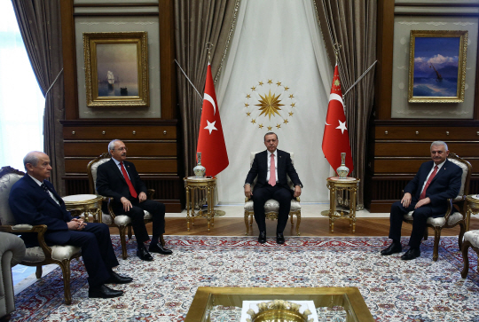 25일(현지시간) 터키 수도 앙카라에 위치한 대통령관저에서 레제프 타이이프 에르도안(왼쪽 세 번째) 터키 대통령이 제1야당인 공화인민당(CHP)의 케말 클르츠다로을루(왼쪽 두 번째) 당 대표, 데블렛 바흐첼리(왼쪽 첫 번째) 민족주의행동당(MHP)당 대표, 비날리 이을드름(왼쪽 네 번째) 터키 총리와 회담하고 있다. 이날 에르도안 대통령은 야당에 헌법개정에 대한 협조를 요청한 것으로 알려졌다.  /앙카라=AP연합뉴스