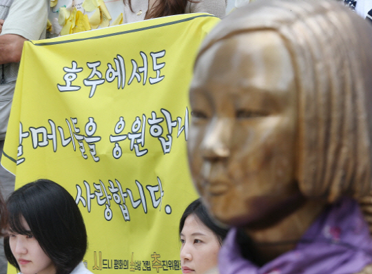 호주에서 내달 6일 시드니에 ‘평화의 소녀상’이 들어설 예정인 가운데, 일본 측의 방해 작업이 집요하게 펼쳐지고 있다. 사진은 지난달 29일 오후 서울 종로구 옛 일본대사관 앞에서 열린 제1237차 일본군 위안부 문제해결을 위한 수요집회에서 평화의 소녀상 뒤로 시드니 평화의 소녀상 건립 추진위원회 관계자가 현수막을 들고 있는 모습./ 연합뉴스