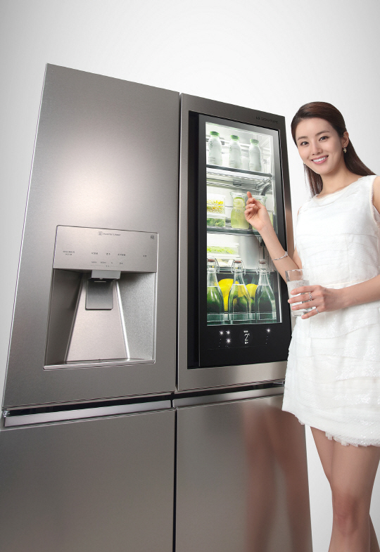 LG전자 모델이 27일 출시된 초프리미엄 ‘LG 시그니처’ 냉장고를 소개하고 있다. 지난 3월 출시된 LG 시그니처 냉장고에 얼음정수기를 결합한 이 제품의 출고 가격은 1,190만원으로 빌트인을 제외하고 국내에서 판매되는 냉장고 중 가장 비싸다. /사진제공=LG전자