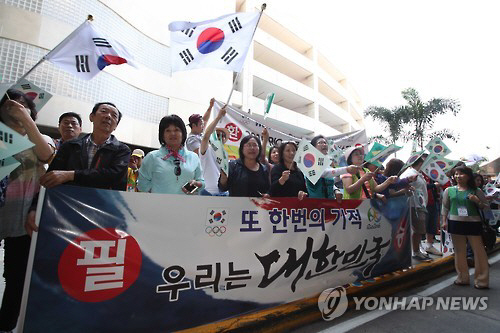 27일(현지시간) 브라질 리우데자네이루 갈레앙 공항에서 상파울루 거주 교민들이 대한민국 대표팀 리우 입성을 환영하며 열띤 응원전을 펼치고 있다./출처=연합뉴스