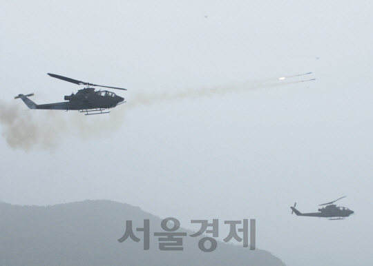 하늘에서 쏟아지는 벼락. 28일 서북도서방위사령부가 실시한 해상 사격 훈련에 참가한 백령도 해병 6여단의 코브라 공격헬기들이 가상 적의 공기부양정과 상륙정을 향해 2.75인치 로켓을 발사하고 있다