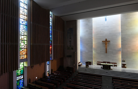 성당의 가장 핵심적인 공간인 성전. 자연 채광을 최대한 활용해 스테인드글라스의 빛이 제단 뒷벽면을 물들이고 있다.