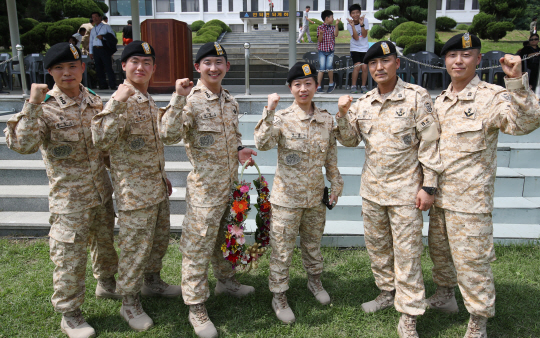 지난 19일 서울 송파구 특수전사령부에서 열린 아크부대 11진 환송식에서 여성으로는 처음 파병되는 정설아 근무원이 장병들과 기념촬영을 하며 파이팅을 외치고 있다. 2011년 1월부터 아랍에미리트(UAE)에 주둔해온 아크부대는 UAE 특수전 부대에 교육훈련을 지원하고 연합훈련을 수행하며 유사시 현지 우리 국민을 보호하는 임무를 맡고 있다. /연합뉴스